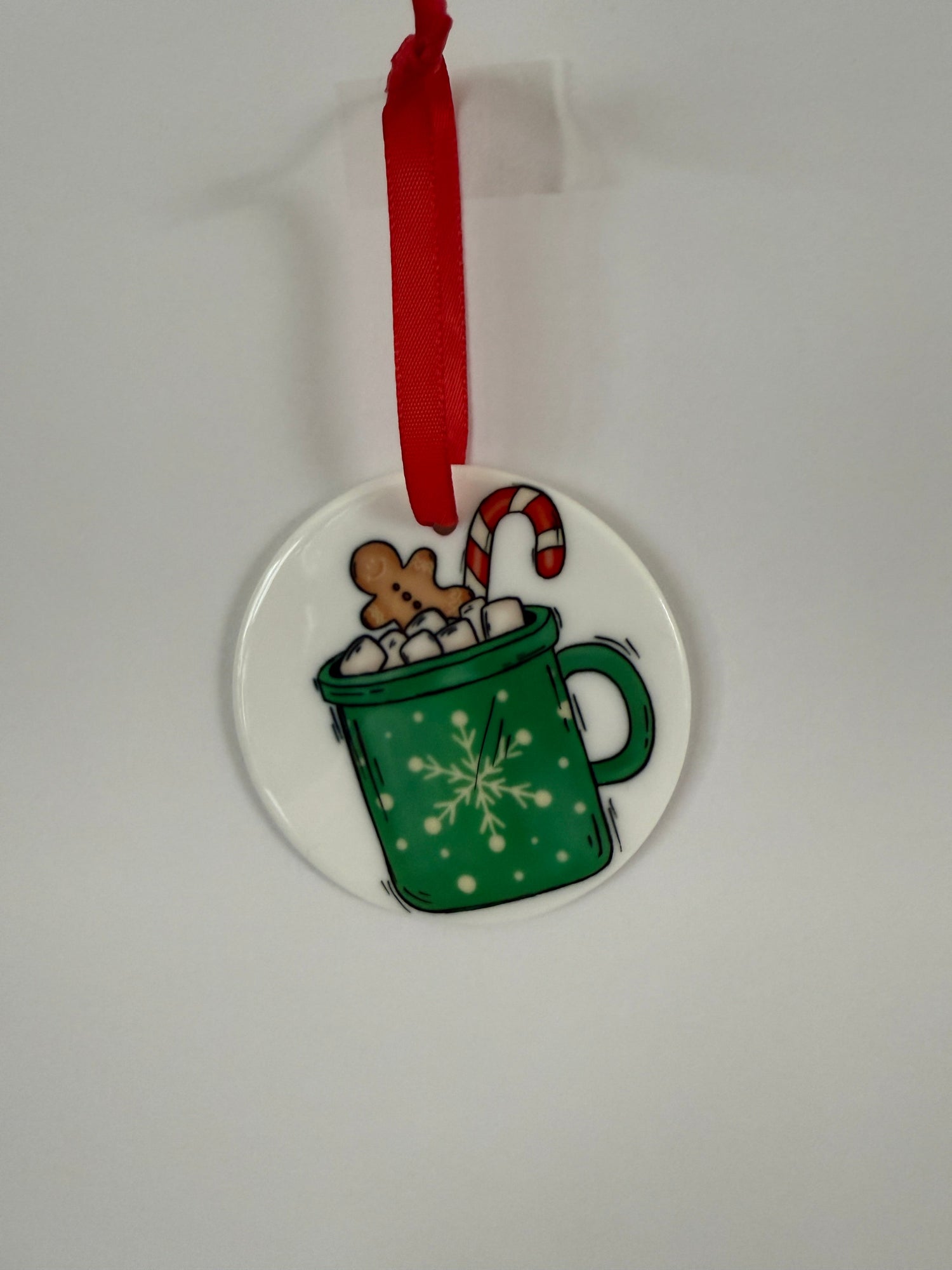 Handmade holiday ornaments featuring a festive green mug with marshmallows, a gingerbread man, and a candy cane