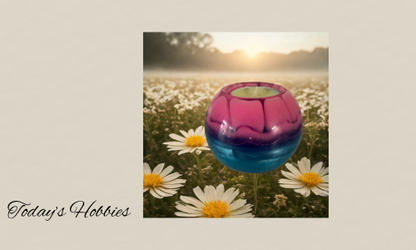 Today’s Hobbies artistic resin home decor piece in pink and blue colors displayed outdoors among daisies
