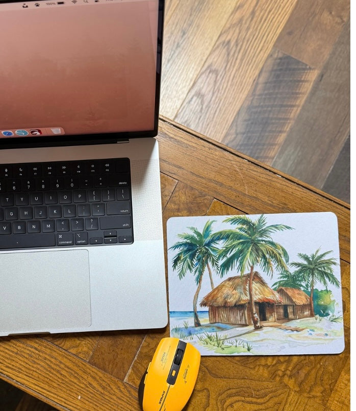 Sublimation mouse pad with tropical beach hut design next to laptop and yellow mouse handcrafted gift ideas