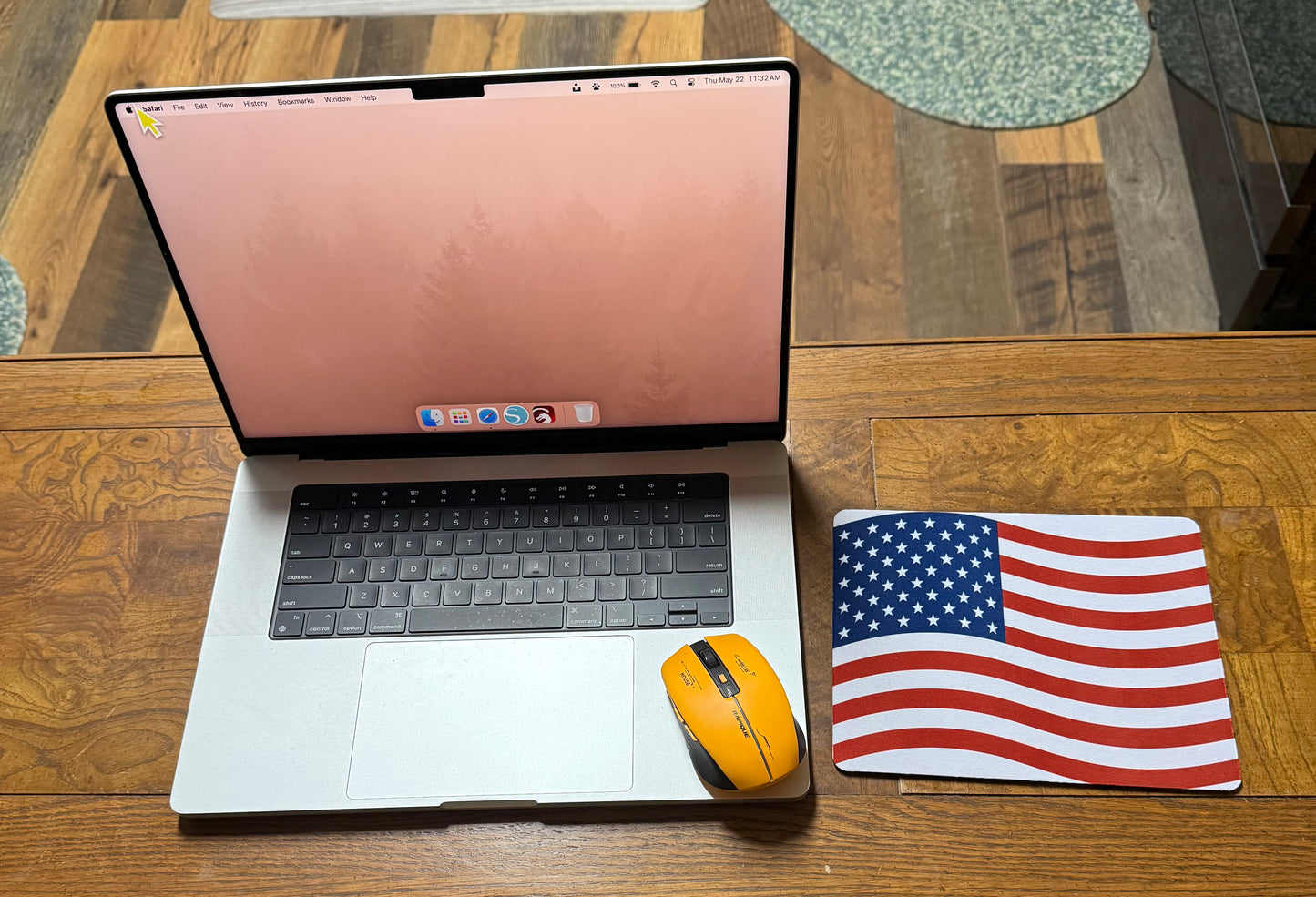 Laptop with orange wireless mouse next to a sublimation print of an American flag showcasing handcrafted gift ideas