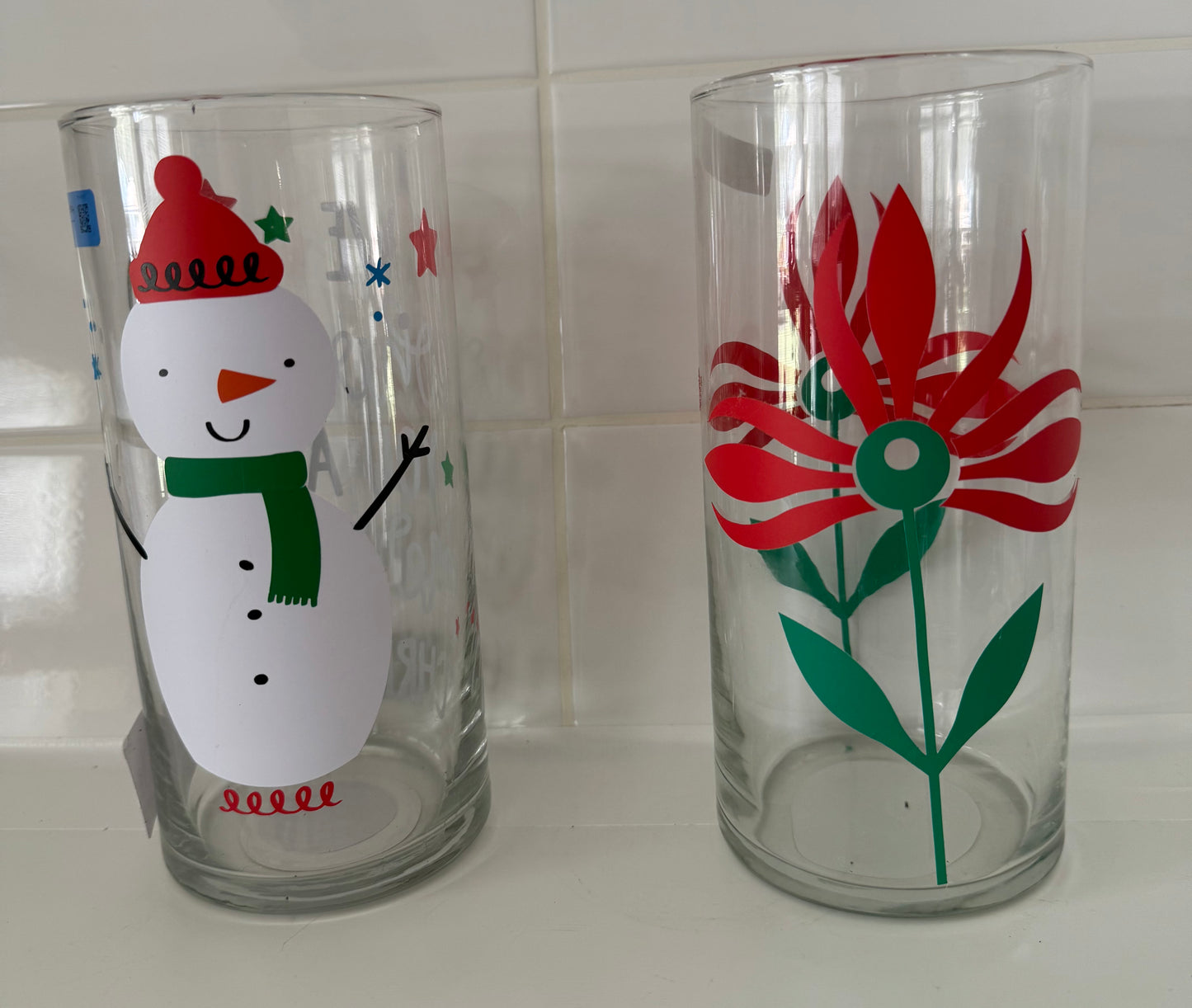 Two upcycled glass vase pieces from Today’s Hobbies featuring a snowman and a red flower design